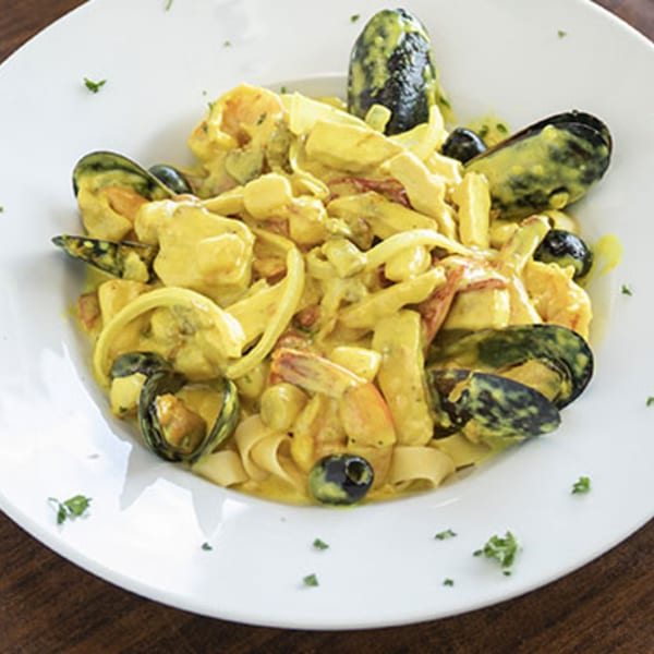 Villa Vinci's seafood pasta with mussels, shrimp, and olives in a creamy yellow sauce.